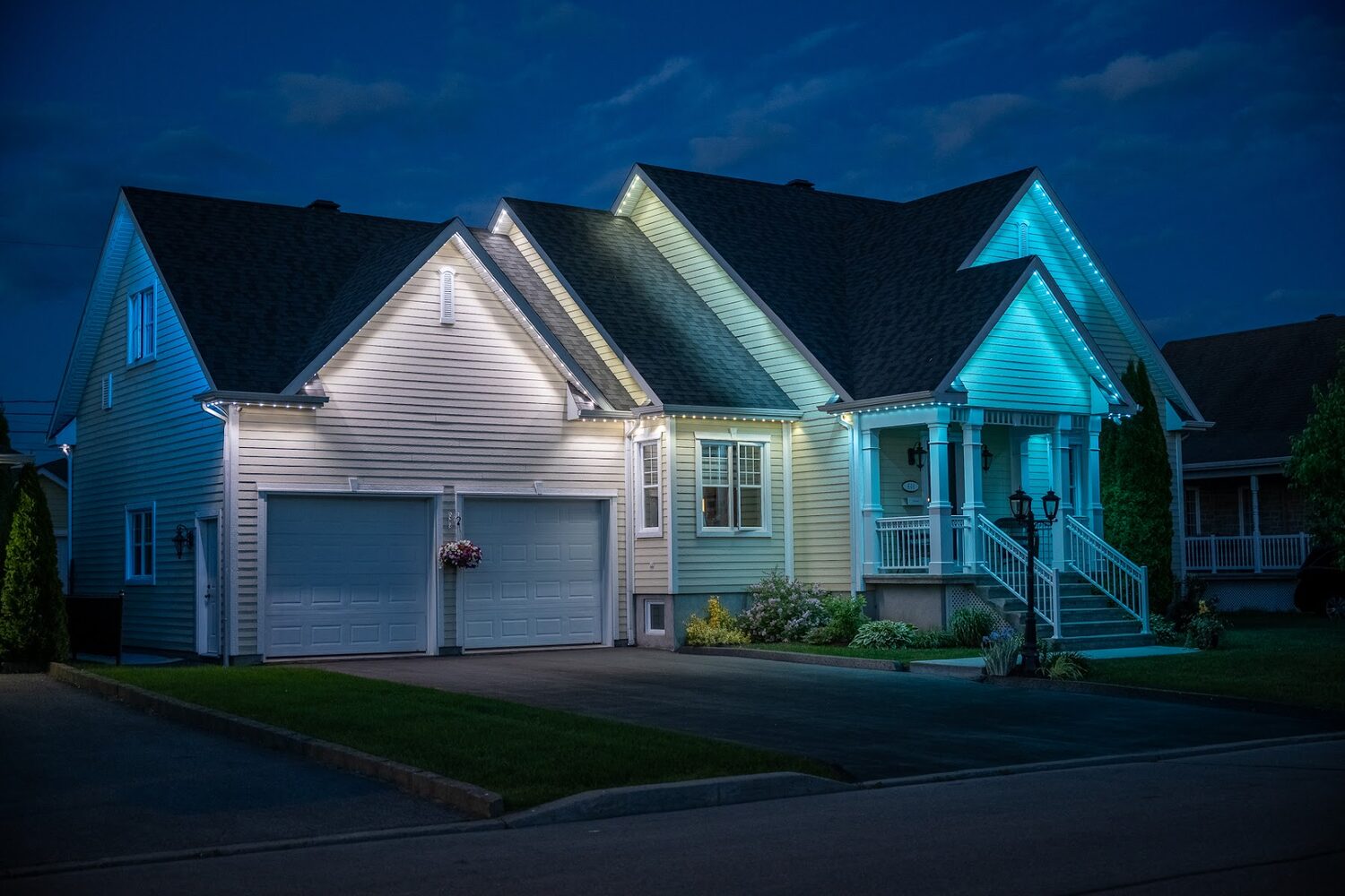 Home lit in cool white with pale blue accents at the eaves