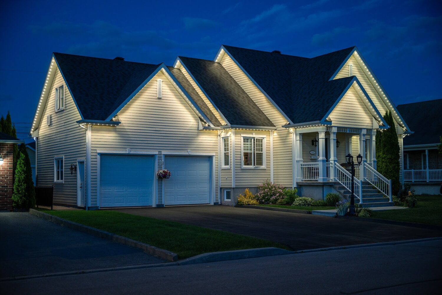 Home lit in warm white with a deep blue sky behind it