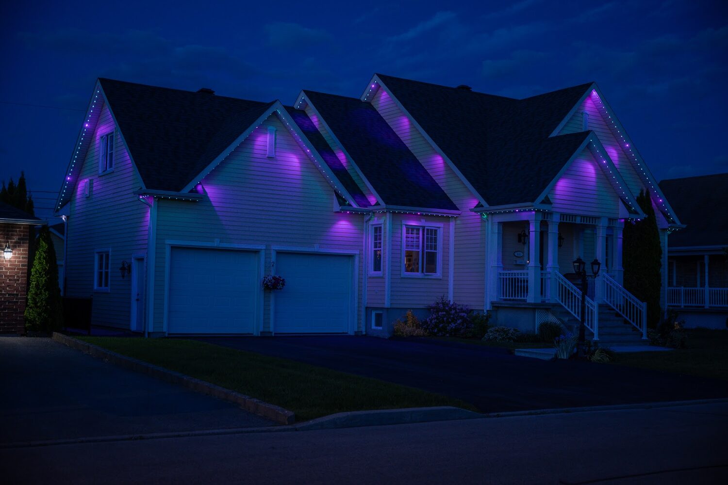 Home lit in violet with cyan accents under the eaves