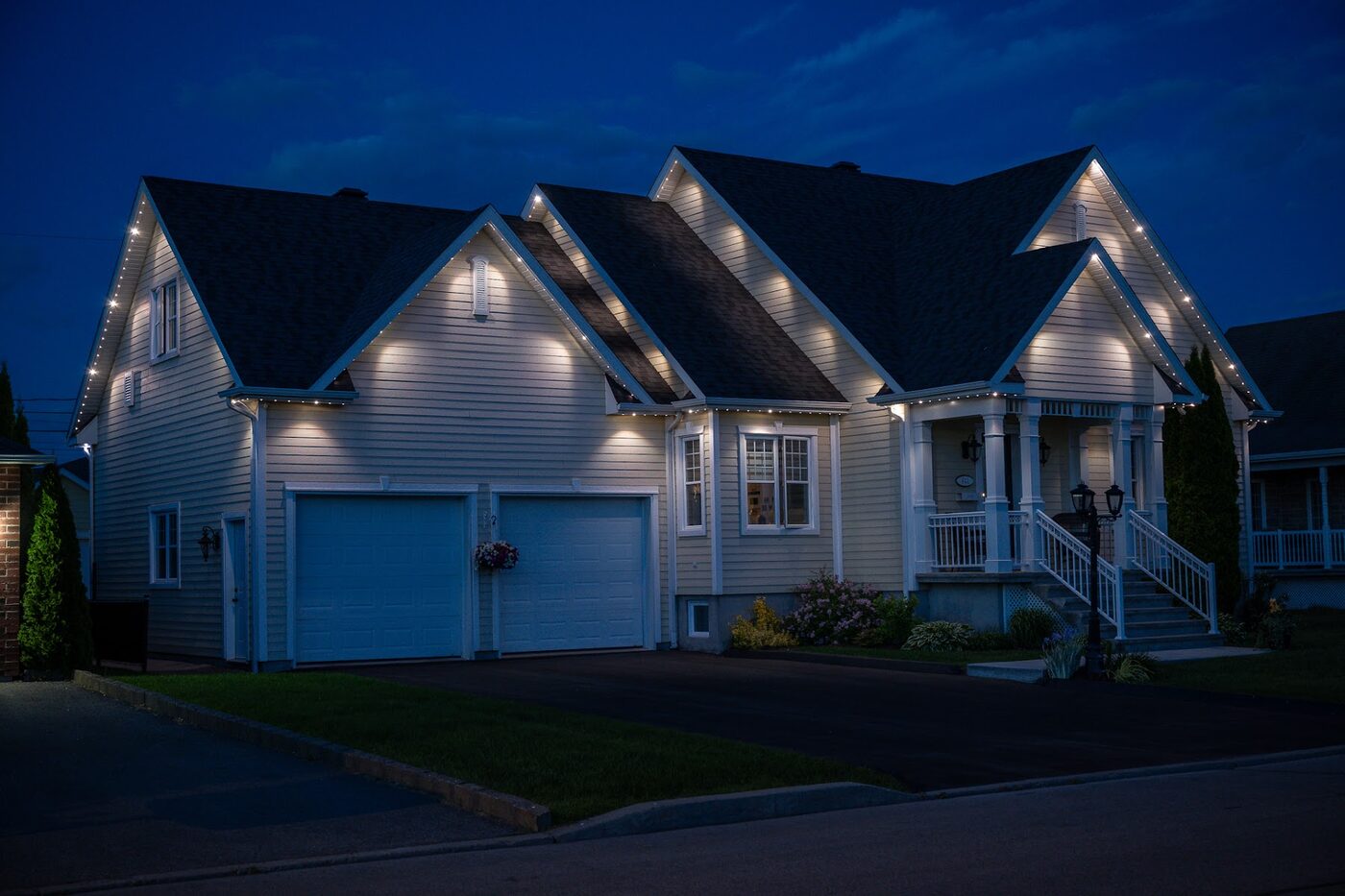 Stone home lit along its roofline at night