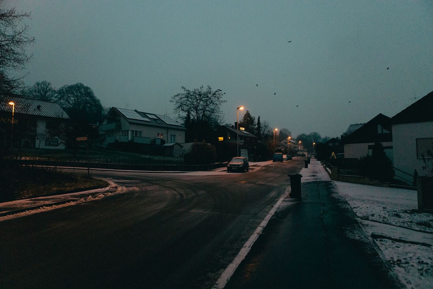 Snow-covered suburban street at twilight